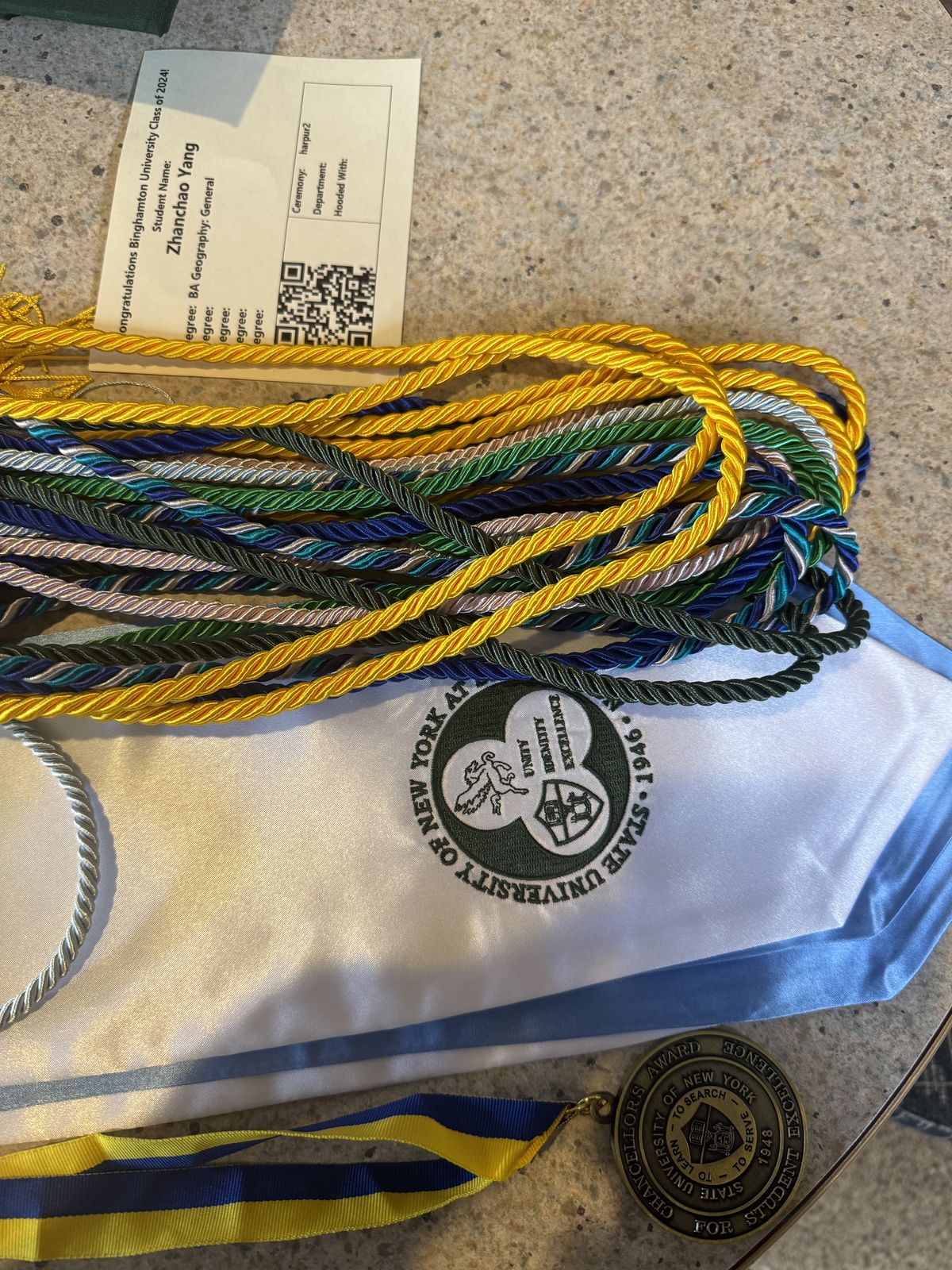 Commencement honor cords, stole, and Chancellor's Award medal laid out for the Binghamton University Class of 2024 ceremony