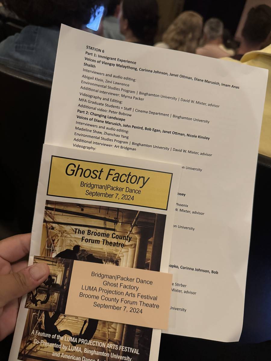 A hand holding the printed program and a Ghost Factory ticket for September 7, 2024 at the Broome County Forum Theatre, part of the LUMA Projection Arts Festival.